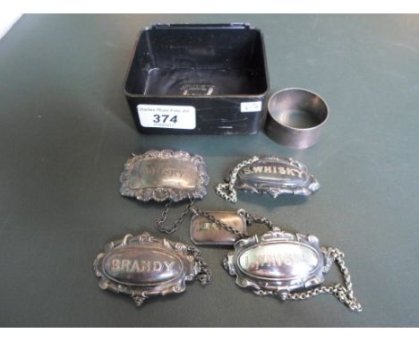 Five silver and white metal decanter labels of varying form, together with a single silver napkin ring.