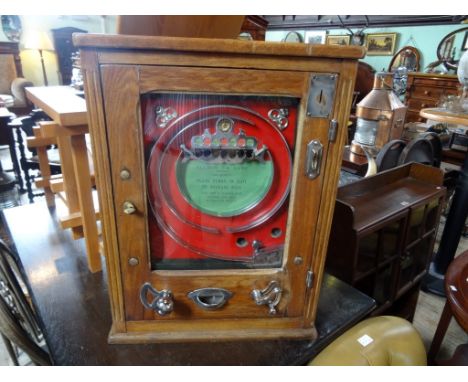 An early 20th century Allwin De-Luxe Penny in the Slot machine, in fitted table top oak case, (65 x 48 x 18cm).