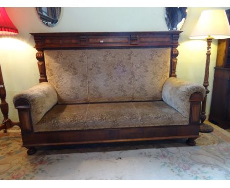 A 19th century Dutch walnut three seater sofa of imposing proportions, having upholstered over-stuffed seat and carved archit