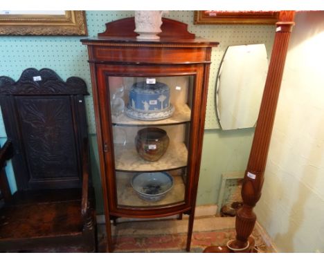 An Edwardian bow fronted mahogany and inlaid glazed display cabinet on tapering supports, (59cm wide).