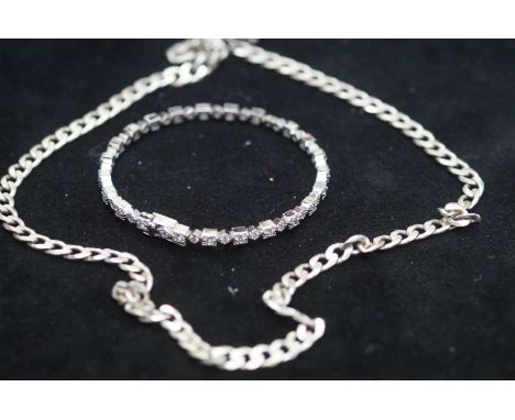 Silver curb chain together with a silver bangle 