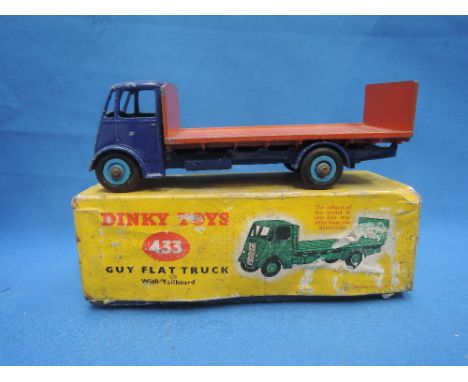 A Dinky die-cast Guy flat truck with tailboard with blue chassis and cab, orange bed and light blue hubs, in original box 433