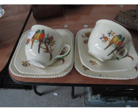 Two cups, saucers and plates with bird and floral pattern
