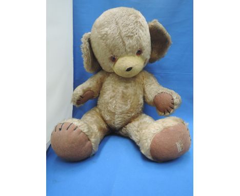 A mid 20th century Merrythought straw filled Teddy Bear having plastic eyes and stitched mouth, bell in ear and jointed body