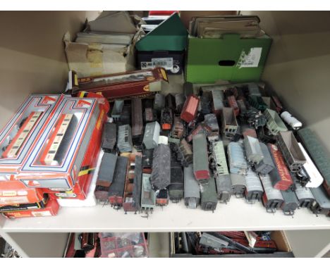 A shelf of Hornby and similar OO gauge rolling stock, some with boxes