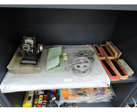 A vintage cinematograph with a selection of coloured slides, screen and reel