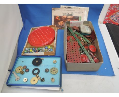 A selection of vintage Meccano including gears outfit, a part set and a bakelite Solitaire board with marbles