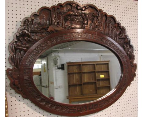 Chinese wall mirror in a carved and stained wooden frame, height of glass 36.5cm width 57cm, with a typical border of fret an