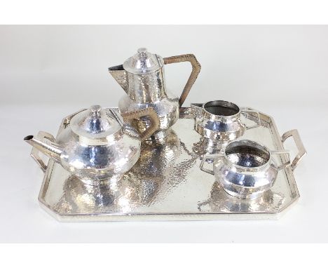 A "Battle-Axe" English Pewter five piece tea set, hammered design, comprising tea pot and hot water jug, both with rush cover