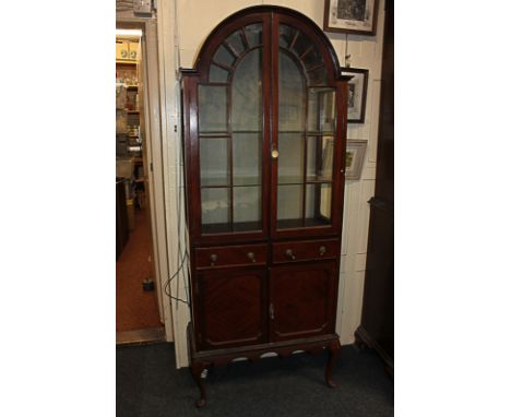 An early 20th century Queen Anne style mahogany display cabinet, with panel glazed dome top, enclosing two glass shelves, abo