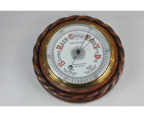 A Victorian aneroid barometer, the dial marked Webster Bros 4 Porchester Road Bayswater, in circular rope twist carved frame,