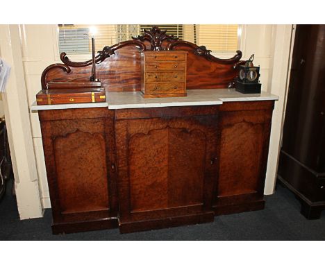 A fruitwood and mahogany break front sideboard with white marble top, central drawer above three arched panel doors, on plint