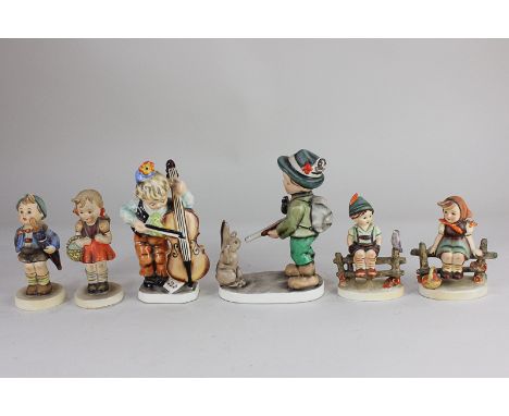 Four Goebel Hummel figures of children, together with two larger similar Friedel Bavarian figures of a boy playing the cello 