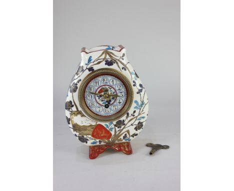 A French pottery mantle clock, the painted dial with Arabic numerals, the movement stamped JD, the case decorated in the Japa