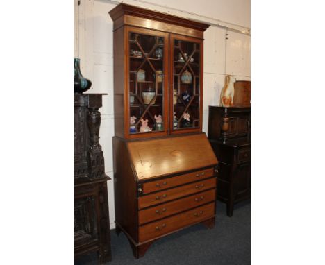 An Edwardian inlaid mahogany bureau bookcase with panel glazed doors enclosing three shelves above fall front and three drawe