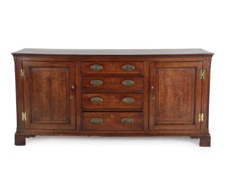 A George III Oak Enclosed Dresser Base, 3rd quarter 18th century, the moulded top above a central bank of four graduated draw