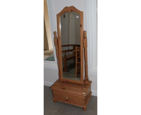 A Pine Cheval Mirror, the arched rectangular plate within a plain frame pivoting on spindle turned supports, the rectangular 