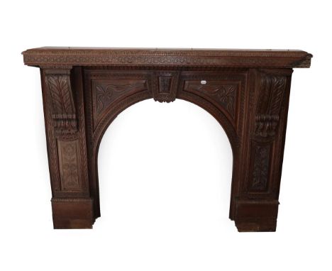 A Victorian Carved Oak Chimney Piece, in two parts, the mantel shelf carved with a lunette and guilloche border above acanthu