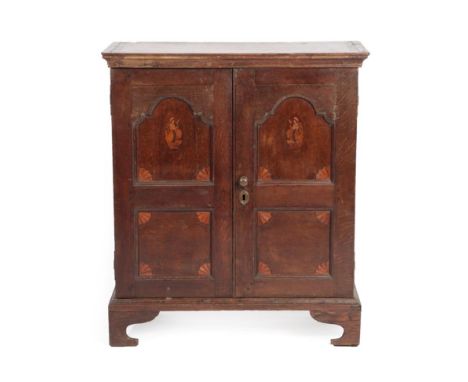 A Mid 18th Century Oak Cupboard, the moulded cornice above arched cupboard doors with four panels decorated with marquetry an