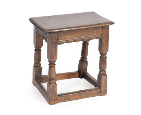 A Late 17th Century Oak Joint Stool, the six peg rectangular top above a moulded and castellated frieze, on turned and block 