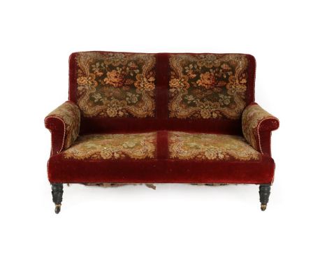 A Late Victorian Two-Seater Sofa, covered in floral carpet, on ebonised turned legs with castors, 145cm by 77cm by 90cm See i