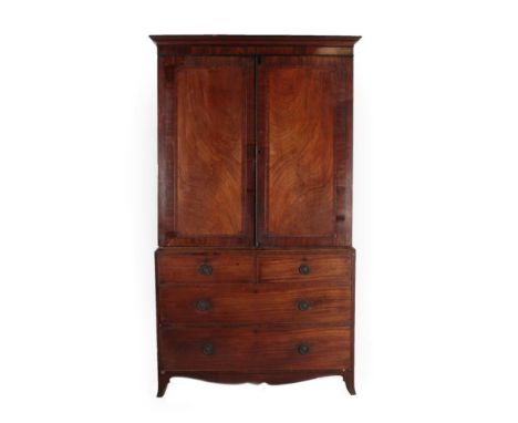 A George III Mahogany, Crossbanded and Ebony Strung Linen Press, late 18th century, the moulded cornice above two moulded cup