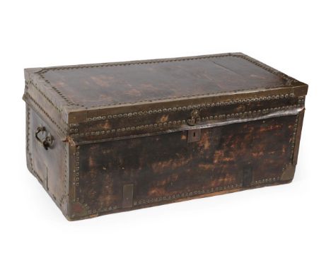 An Early 19th Century Brass Bound and Close-Nailed Leather Trunk, the hinged lid enclosing a red painted and floral decorated