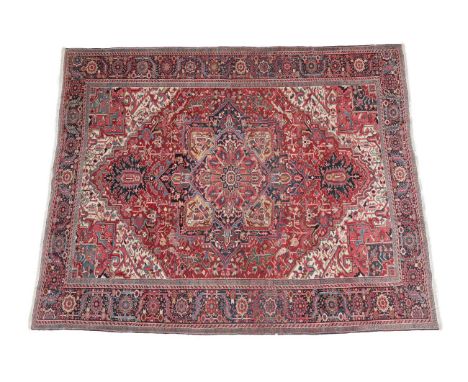 Heriz Carpet North West Iran, circa 1920 The blood red field of angular vines and stylised flower heads around an indigo meda