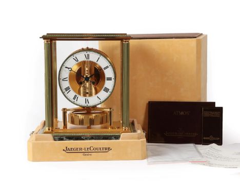 A Brass and Marble Atmos Clock, signed Jaeger LeCoultre, circa 1985, four glass panels with fluted corner columns, marble bas
