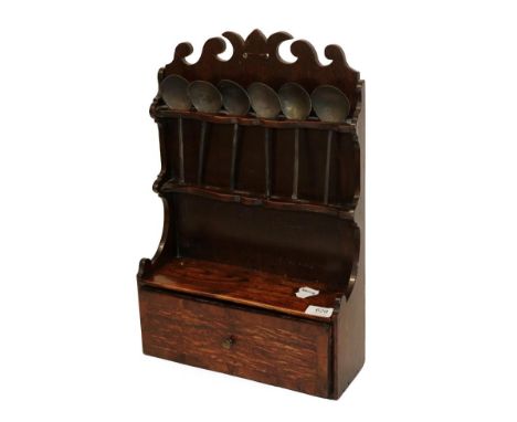 An 18th Century Oak Spoon Rack, the back panel with scrolled pediment and two serpentine shaped small shelves to receive twel