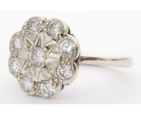 A 9ct hallmarked white gold diamond daisy cluster ring eight brilliant cut stones illusion set to a white gold circular head,