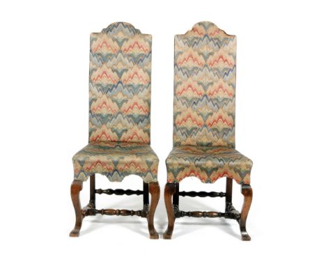A set of four 20th Century Carolean style walnut dining chairs  with arched shaped tapestry backs and seats on cabriole legs 