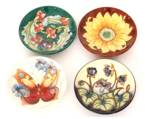 Four assorted Moorcroft Pottery pin dish coasters comprising one in the Butterfly and one in the Leicester pattern, both desi