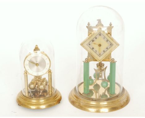 An Art Deco style 365 day mantle clock, the diamond shaped movement supported on twin green pillars in a glass dome and a sim