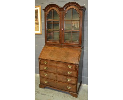 An 18th Century and later cross and feather banded double dome top walnut bureau bookcase, with stepped fitted interior centr