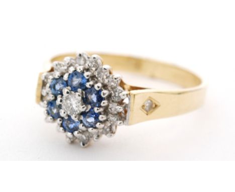 An 18ct hallmarked sapphire and diamond cluster ring central brilliant cut diamond within a six stone diamond surround in tur