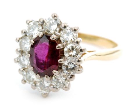 An 18ct ruby and diamond cluster ring, central oval facet cut ruby weighing approximately 1ct, within a border of  ten brilli