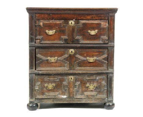 An 18th Century and later constructed oak chest of three geometric moulded panel drawers, brass drop handles and oval escutch