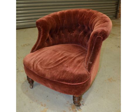 A Victorian tub chair, upholstered in deep red button down velvet above turned mahogany front legs.