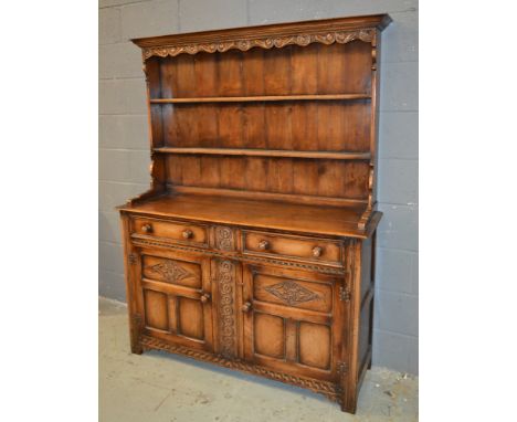 A 17th Century style oak dresser fitted with two frieze drawers over a cupboard base, turned wood handles on block legs, widt