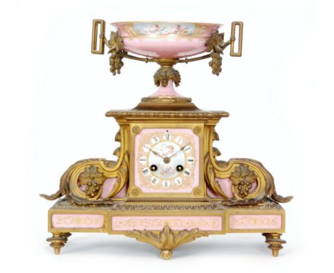 A 19th Century French ormulu eight day mantle clock decorated with pink Sevres style panels, with Roman numerals to a cherub 