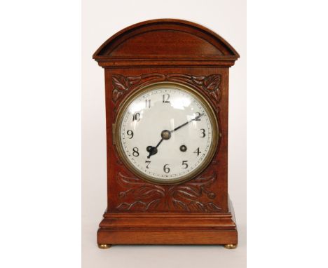 An Edwardian mahogany cased mantle clock with eight day striking movement on a gong, circular Arabic dial within an arched gl