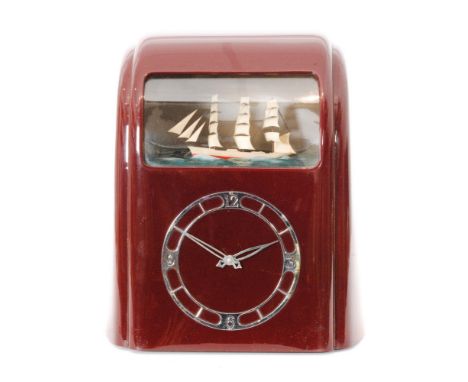 A 1940s Art Deco Vitascope Industries Ltd dark red Bakelite clock, the Odeon style case with a silver coloured dial below a r