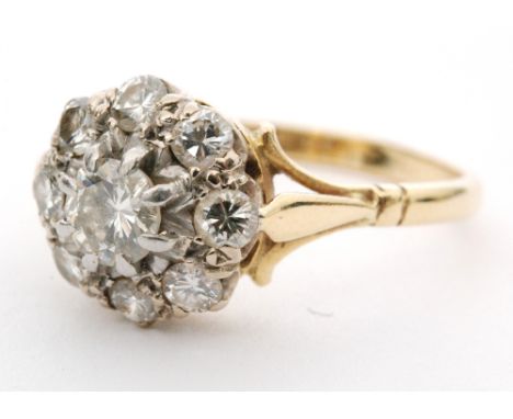 An 18ct diamond daisy cluster ring, central round brilliant cut diamond within an eight diamond surround, forked shoulders to