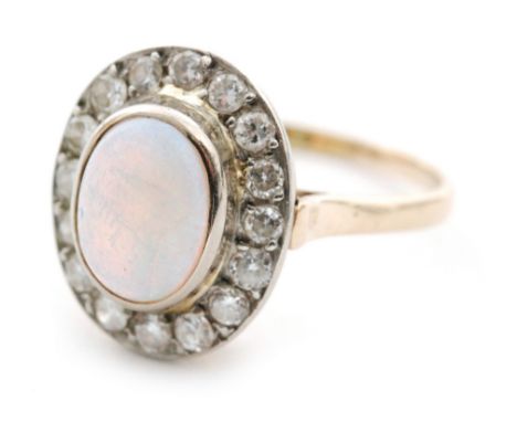 A 14ct opal and diamond dress ring, oval cabochon opal within in a sixteen diamond surround, scrolled mount to a plain taperi