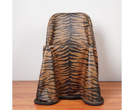A striking trompe-l'oeil fiberglass chair designed to mimic the look of draped fabric with an elegant tiger print pattern. Th
