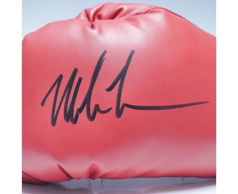 Featured is an Everlast red boxing glove, hand-signed by legendary heavyweight champion Mike Tyson. This professional-style g
