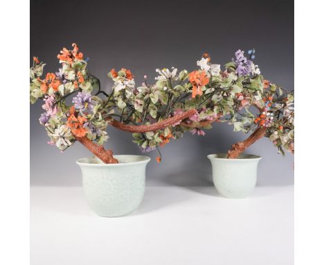 A pair of intricately crafted stone bonsai trees, each adorned with delicate carved stone leaves and flowers in shades of pin