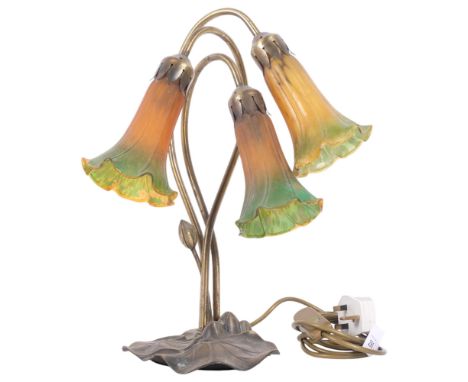 An Art Nouveau inspired Tiffany style table lamp, with decorative lily pad base, and 3 amber and green tulip design glass sha