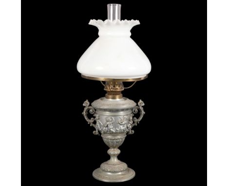 An embossed spelter oil lamp with frieze of cherubs, with chimney and milk glass shade, H49cm